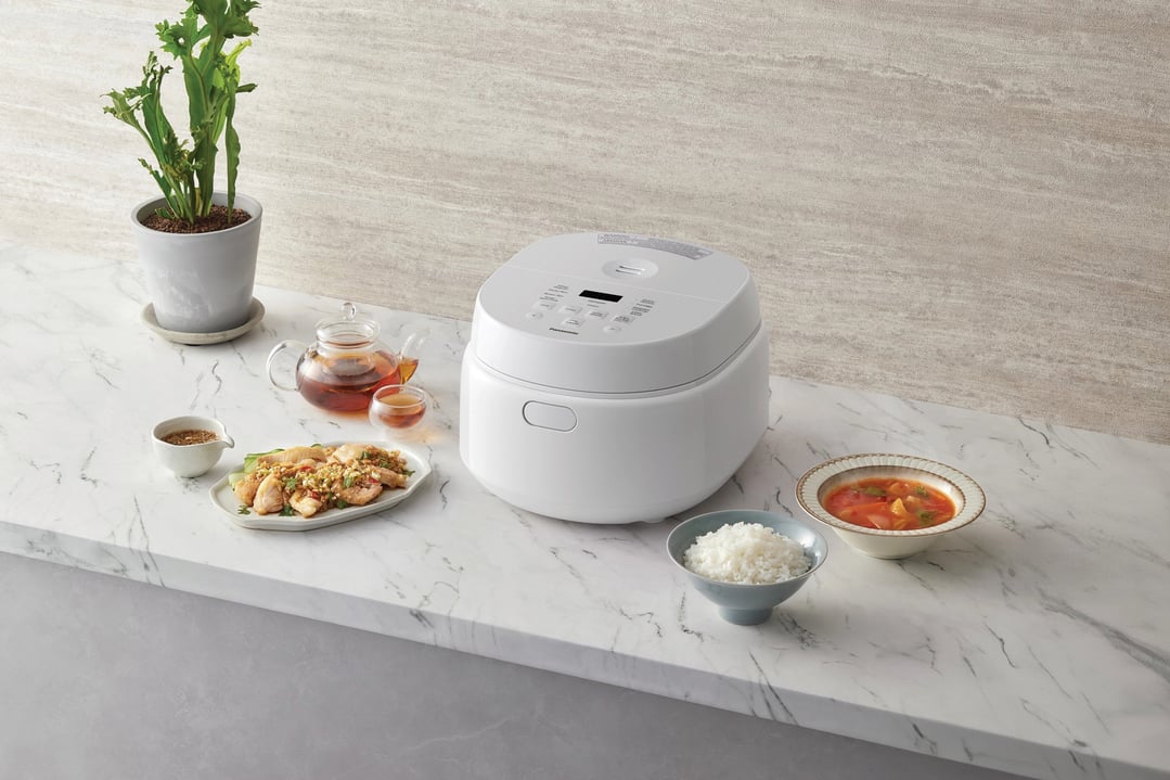Panasonic Premium 5.5-cup Rice & Multi Cooker on a marble counter with food