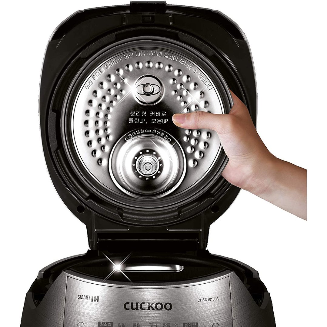 Hand removing the inner lid of a Cuckoo IH pressure rice cooker