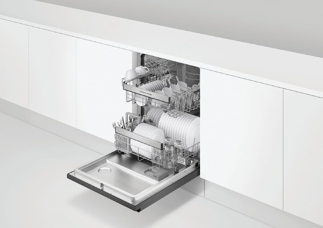 Built-under dishwasher with two racks of clean dishes and cutlery in a white kitchen