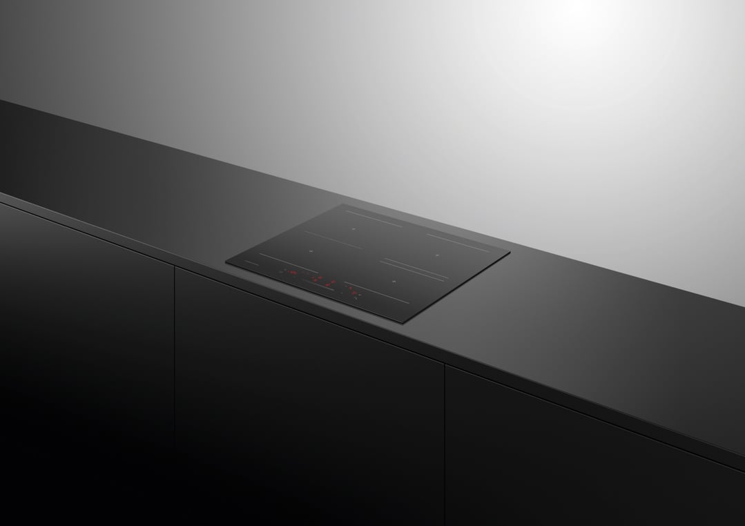 Black induction cooktop built into a dark countertop in a modern kitchen