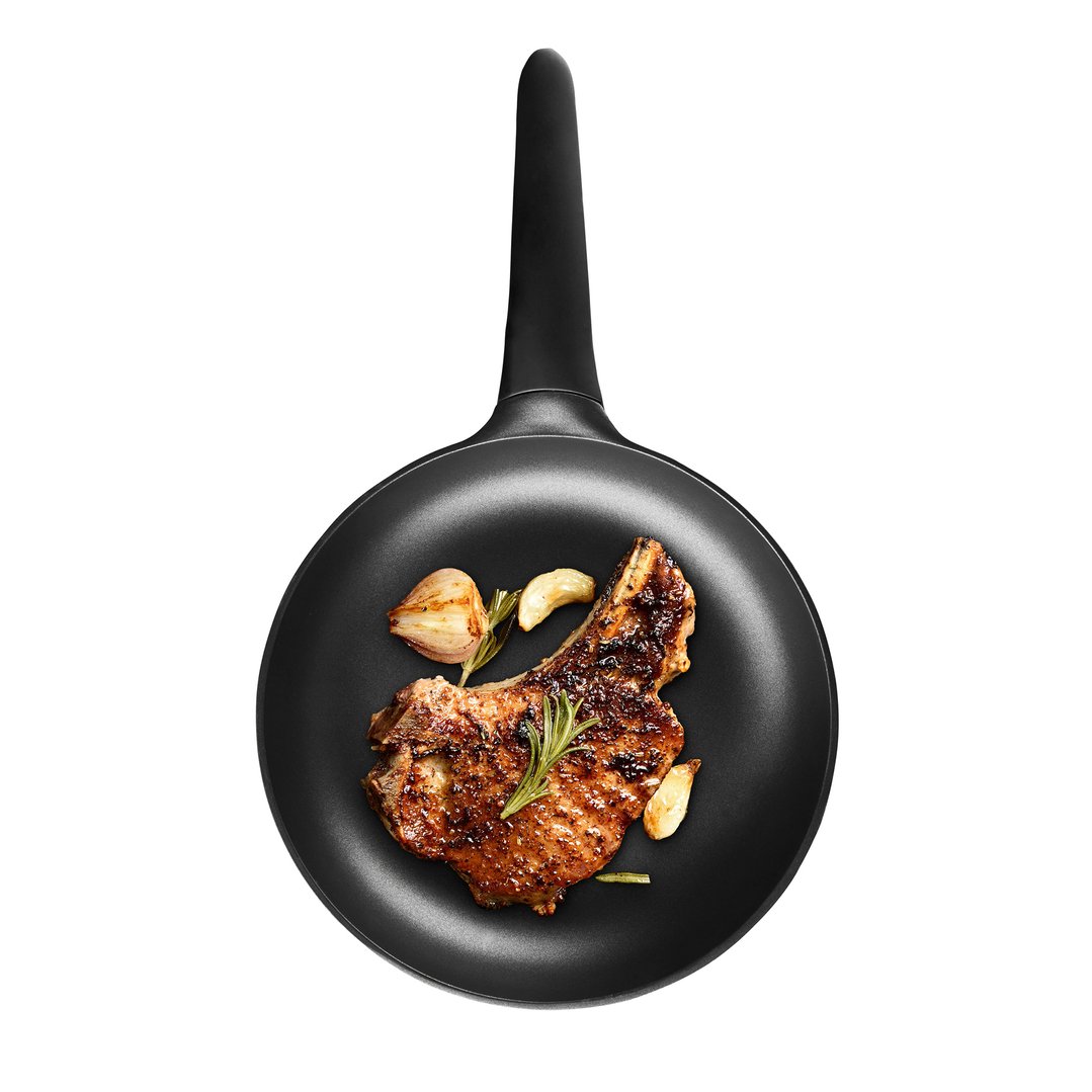 Grilled pork chop with rosemary and garlic in a black electric skillet