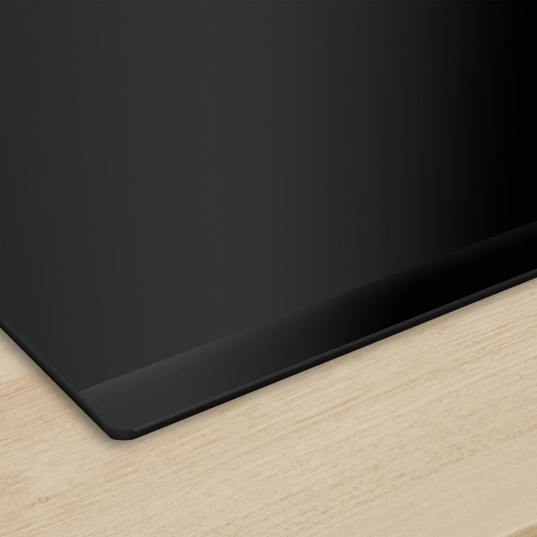 Black induction cooktop integrated into a light wood countertop