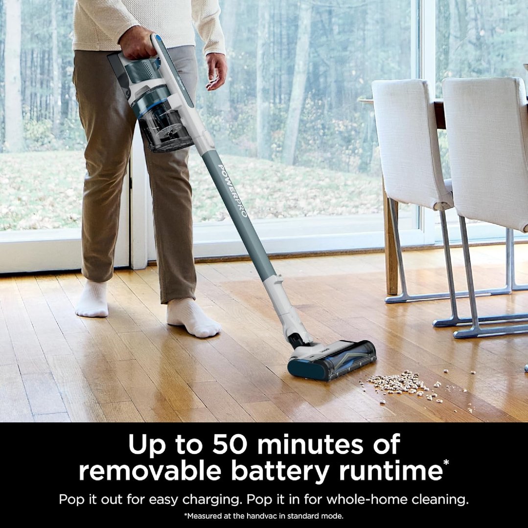 Person using a SHARK PowerPro Plus Cordless Stick Vacuum on a wooden floor