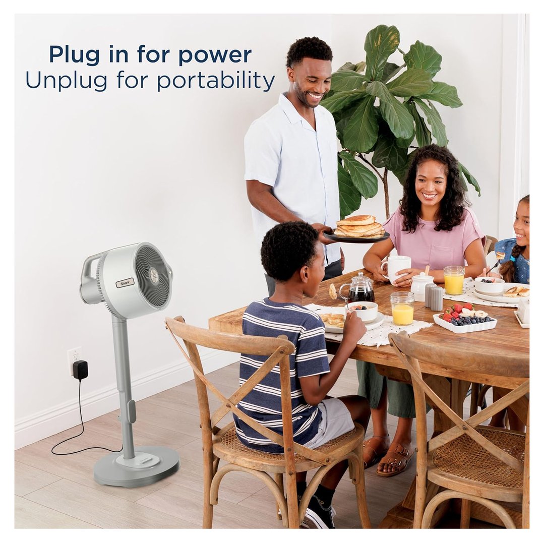 A family having breakfast with a Shark fan plugged into a wall outlet