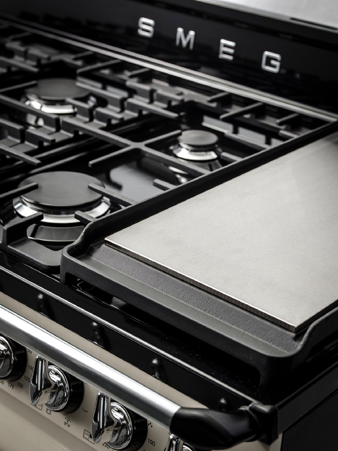 Close-up of a black and cream freestanding dual fuel oven/stove with a griddle