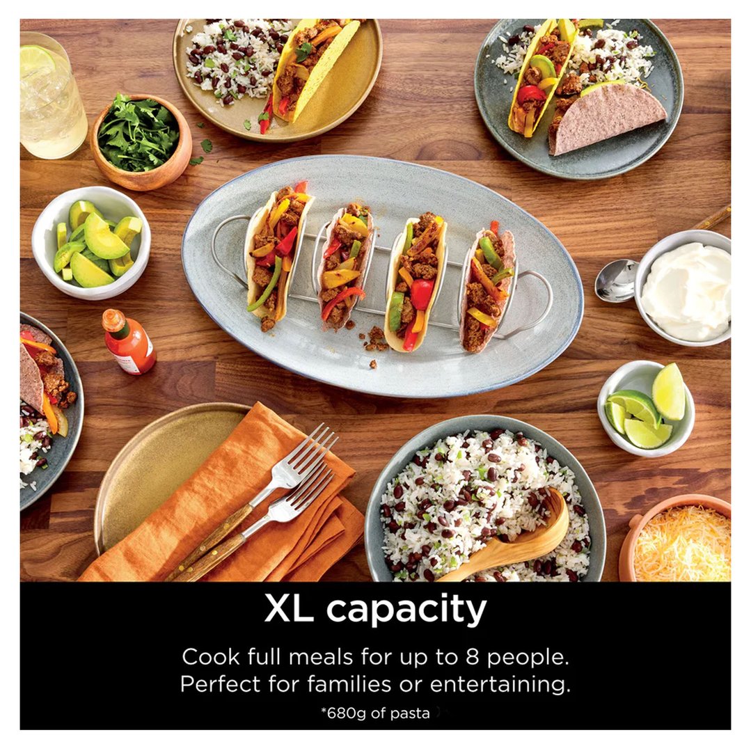 Overhead view of a table laden with tacos, rice, and various toppings