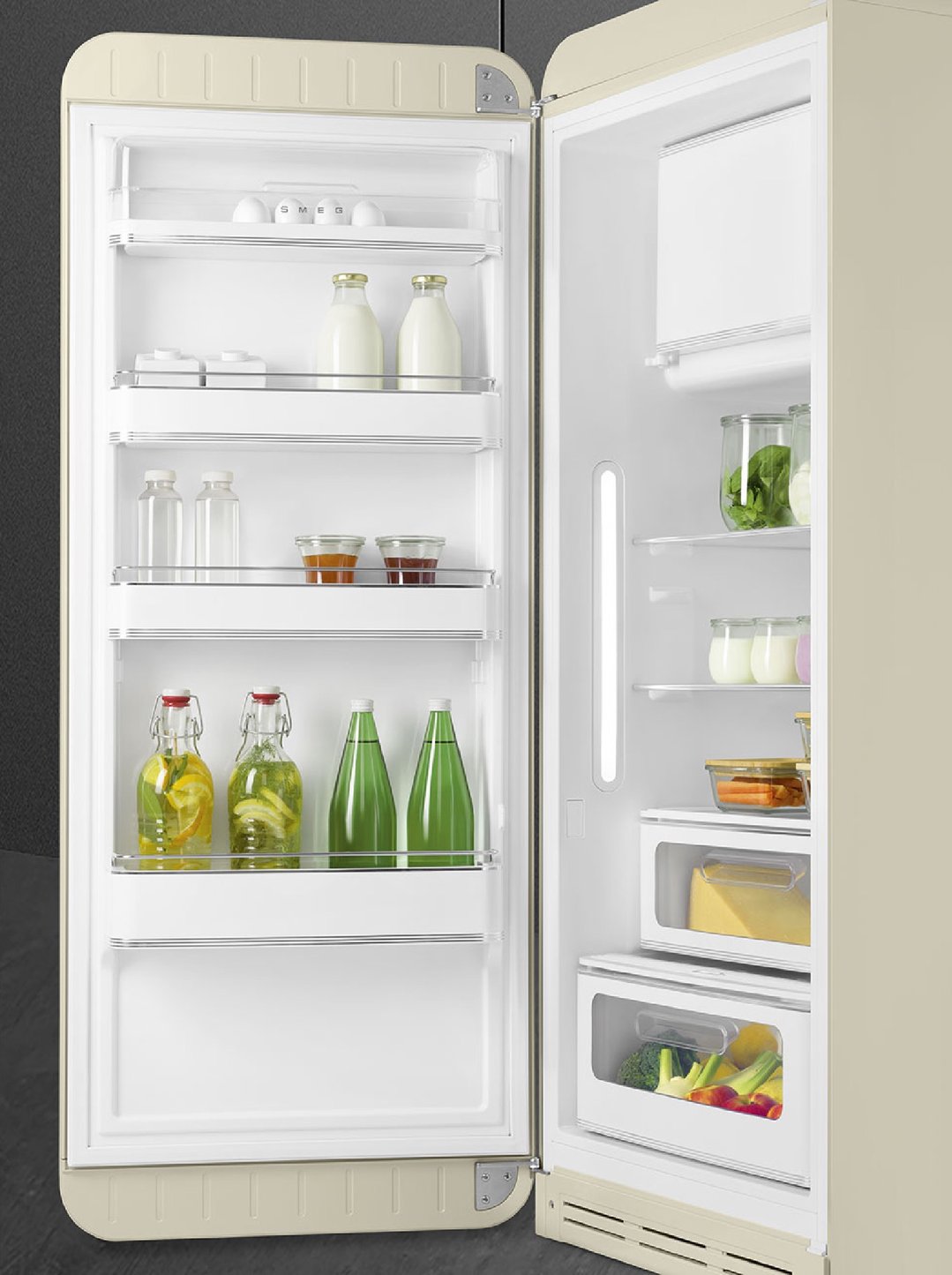 Open cream Smeg retro refrigerator filled with food and drinks