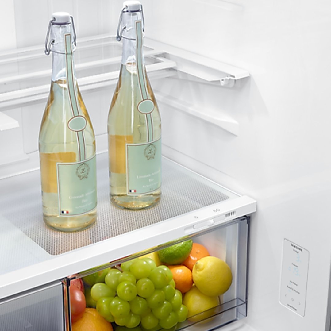 Two bottles and fresh fruit inside a Samsung French Door Refrigerator