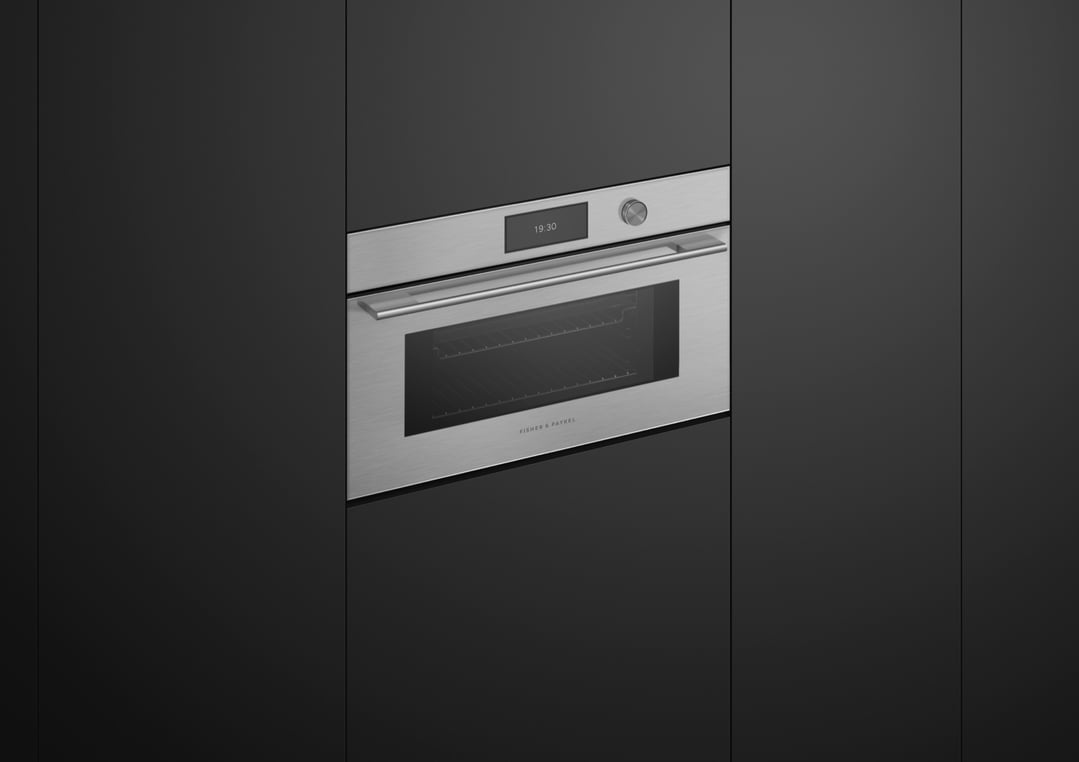 Stainless steel compact combi-steam oven built into dark cabinetry