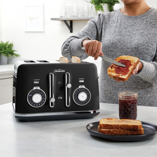 Woman spreading jam on toast next to a black Sunbeam toaster