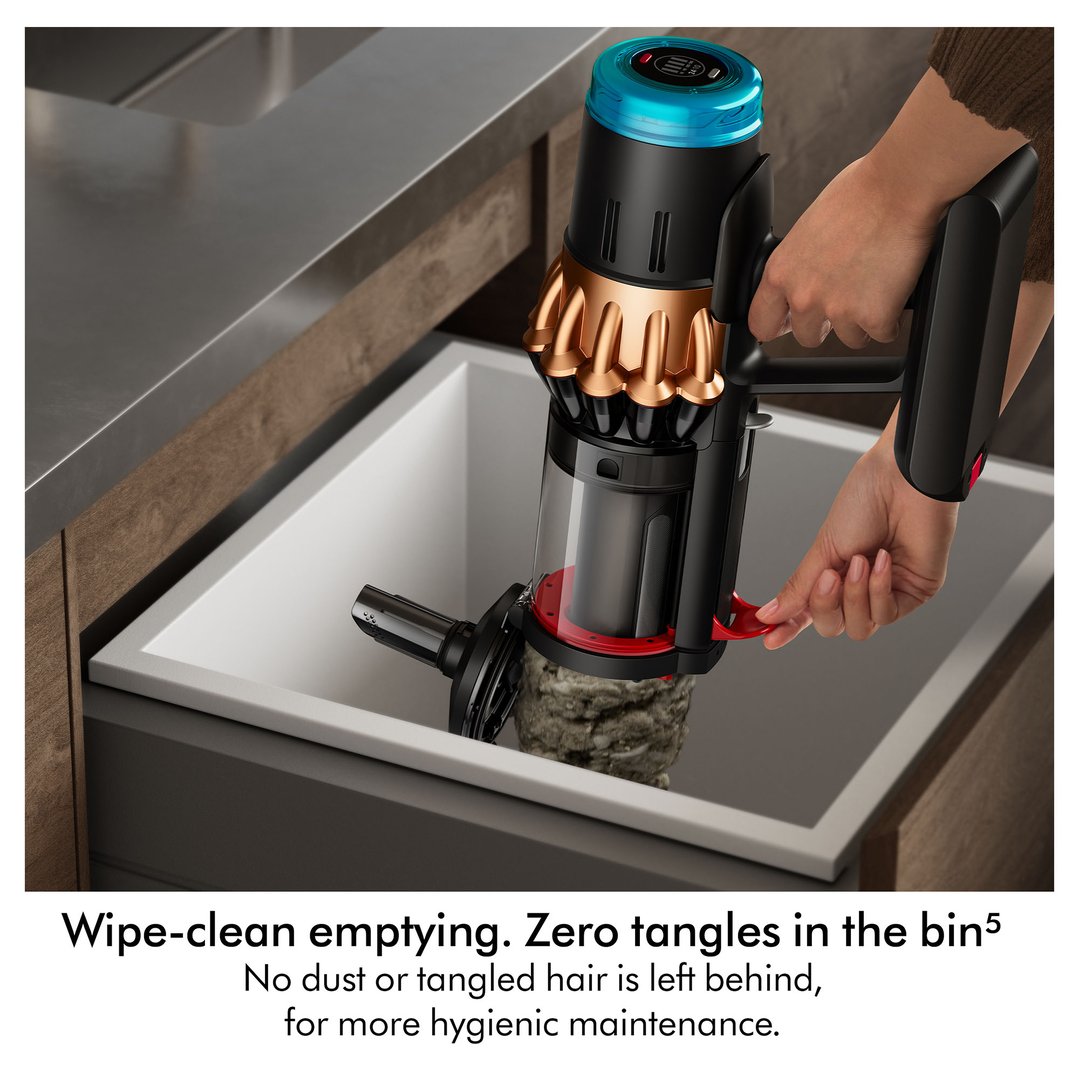 Hand emptying the handstick vacuum cleaner into a kitchen sink