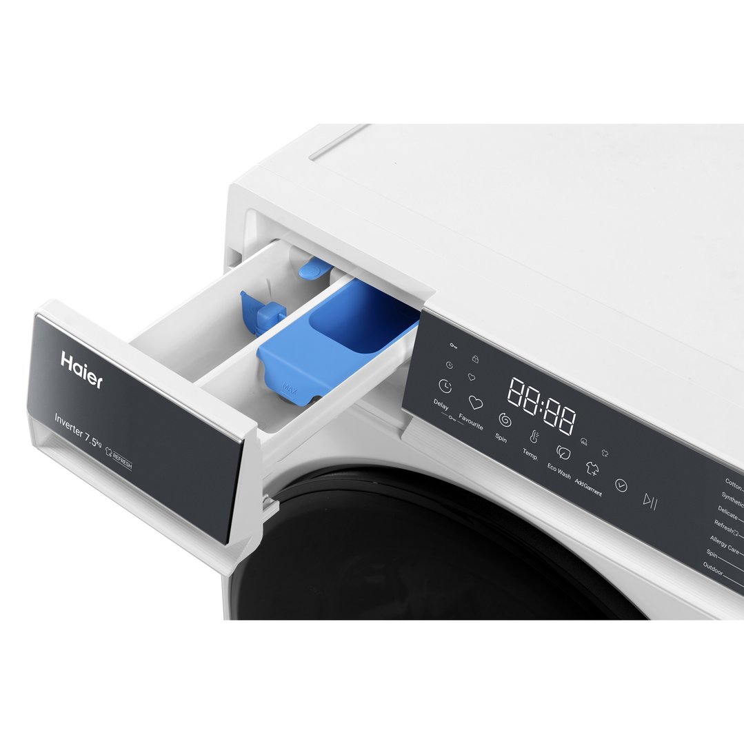Close-up of a white Haier washing machine with the detergent drawer open