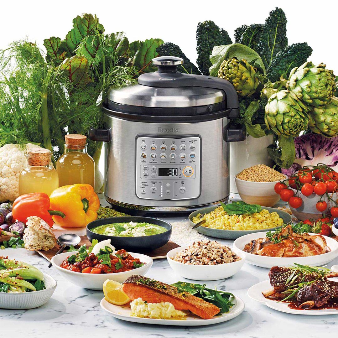Breville Fast Slow GO Pressure Cooker surrounded by fresh ingredients and cooked dishes