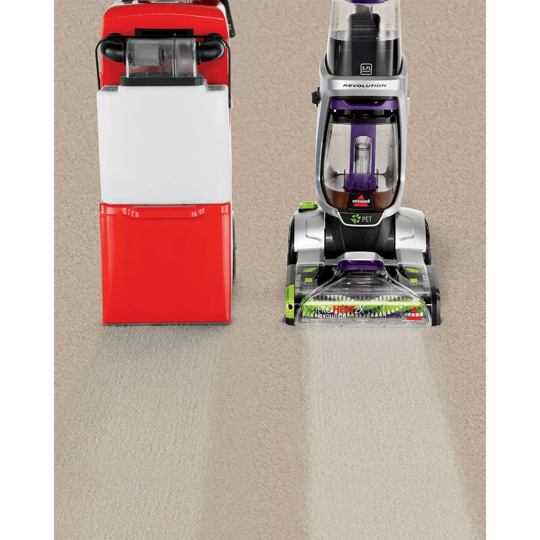 Two carpet washers on a carpet, one actively cleaning a strip