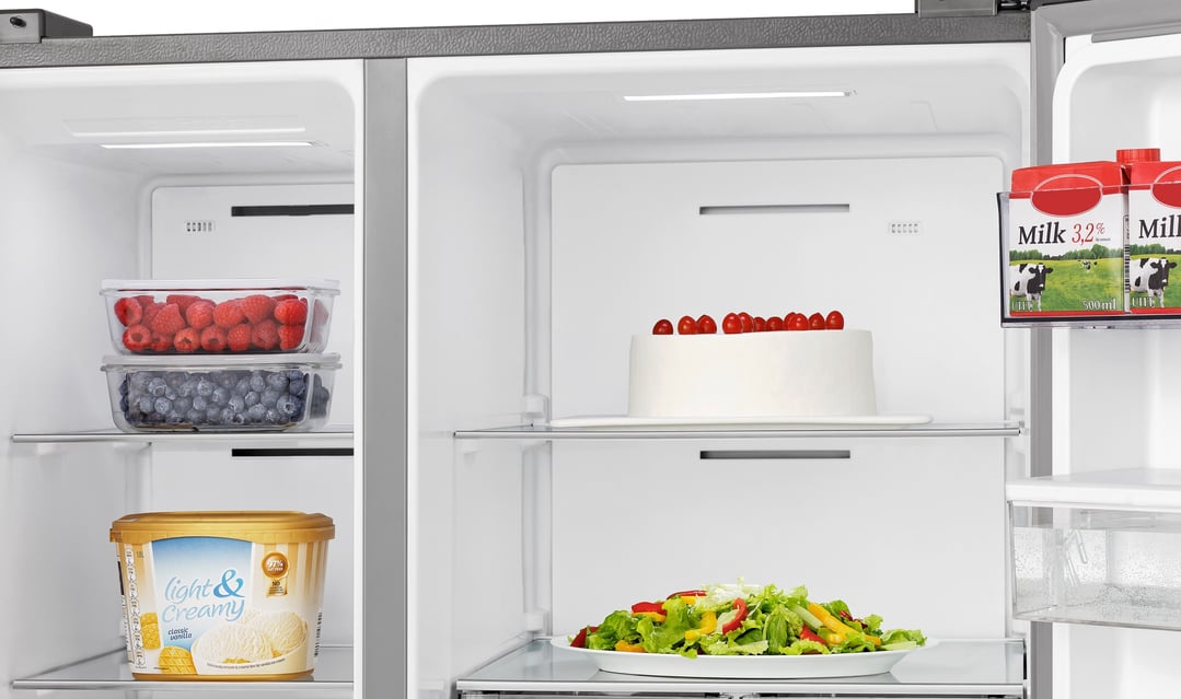 Open side by side fridge with food items on shelves and in door compartments