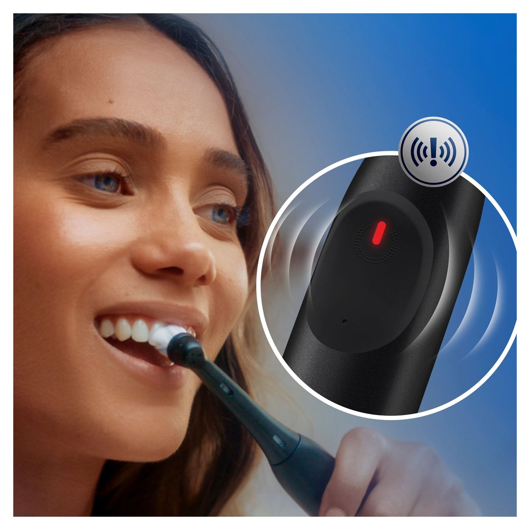 A woman brushing her teeth with an Oral-B iO Series 2 electric toothbrush