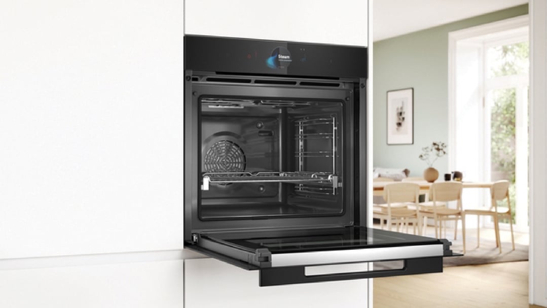 Open multifunction pyrolytic oven with added steam in a modern kitchen setting