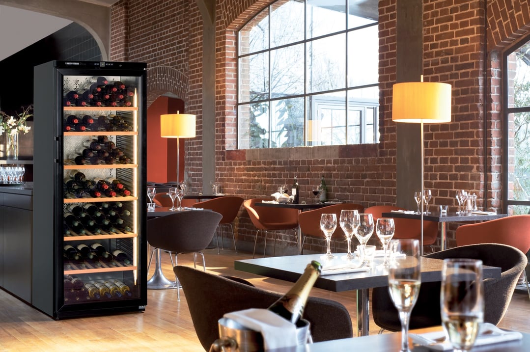 Wine cabinet in a restaurant setting with tables, chairs, and brick walls