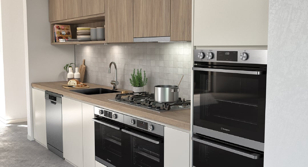 Stainless steel ovens and dishwasher in a modern kitchen with wooden benchtops
