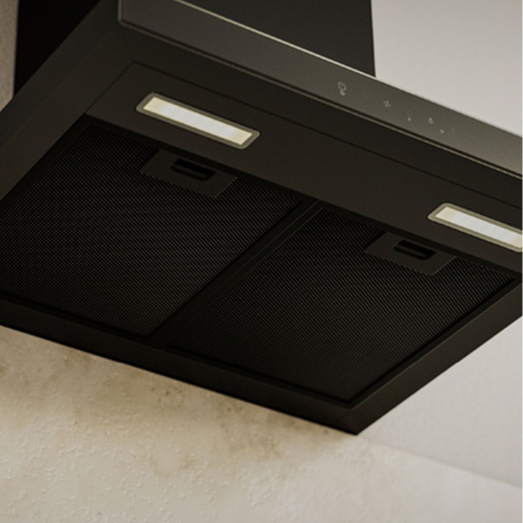 Matte black rangehood with lights on, mounted above a textured wall
