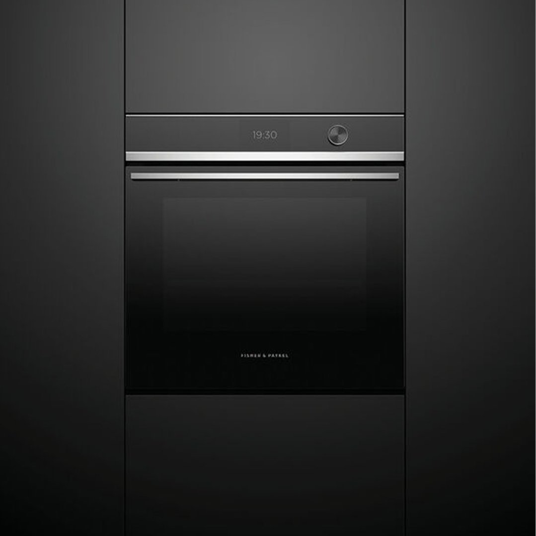 Black built-in oven with digital display showing 19:30 in a dark kitchen