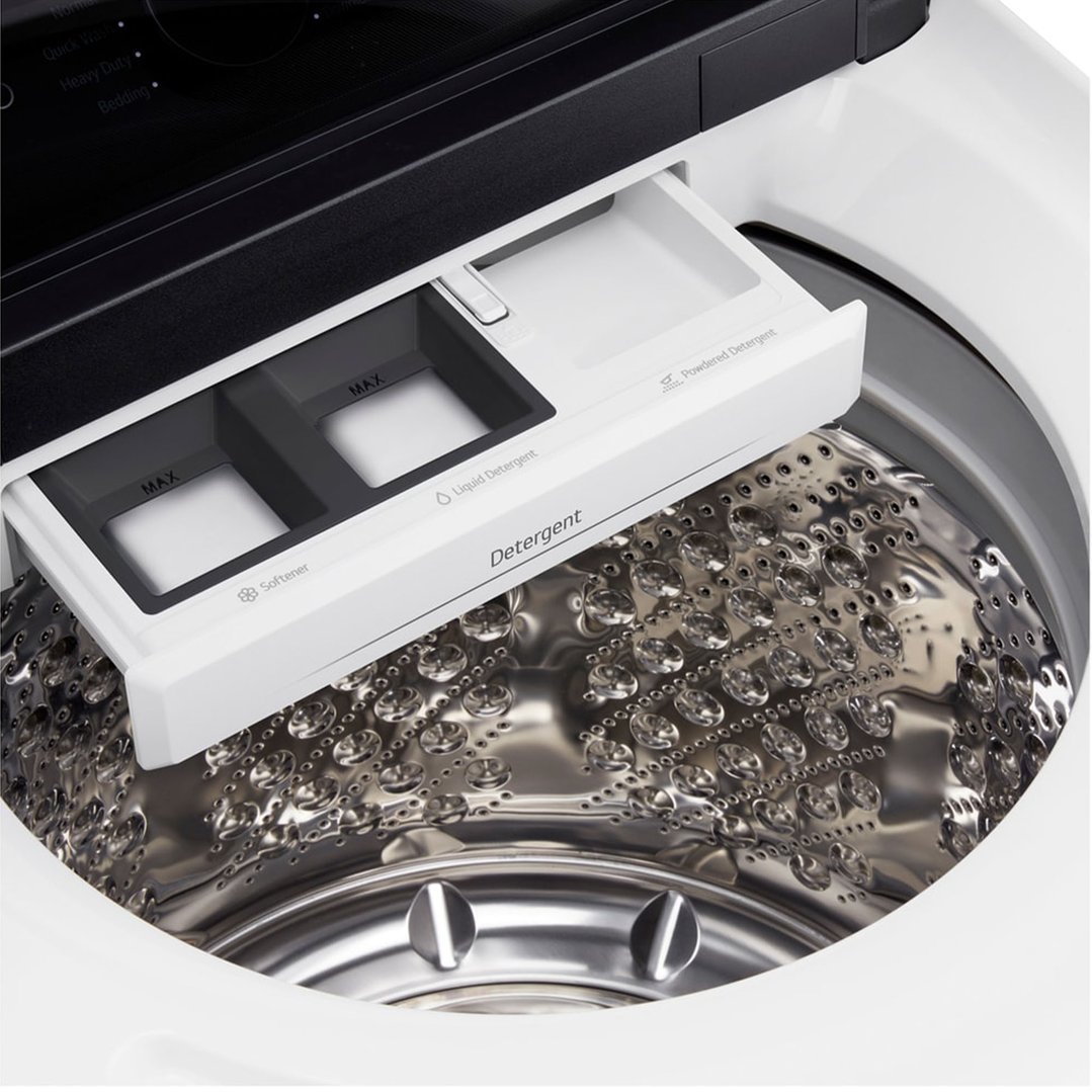 Close-up of the open detergent dispenser and drum of a top load washer