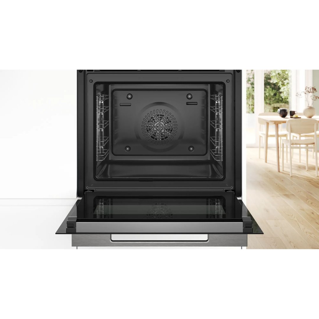 Open oven with interior racks visible, in a kitchen setting