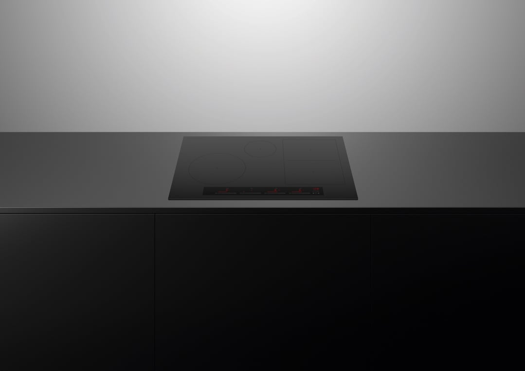 Black induction cooktop built into a dark countertop in a modern kitchen