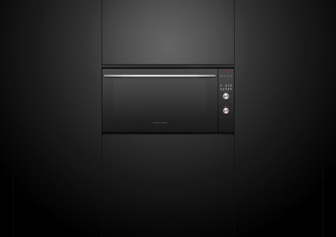 Black built-in oven with digital display and controls in a dark kitchen setting