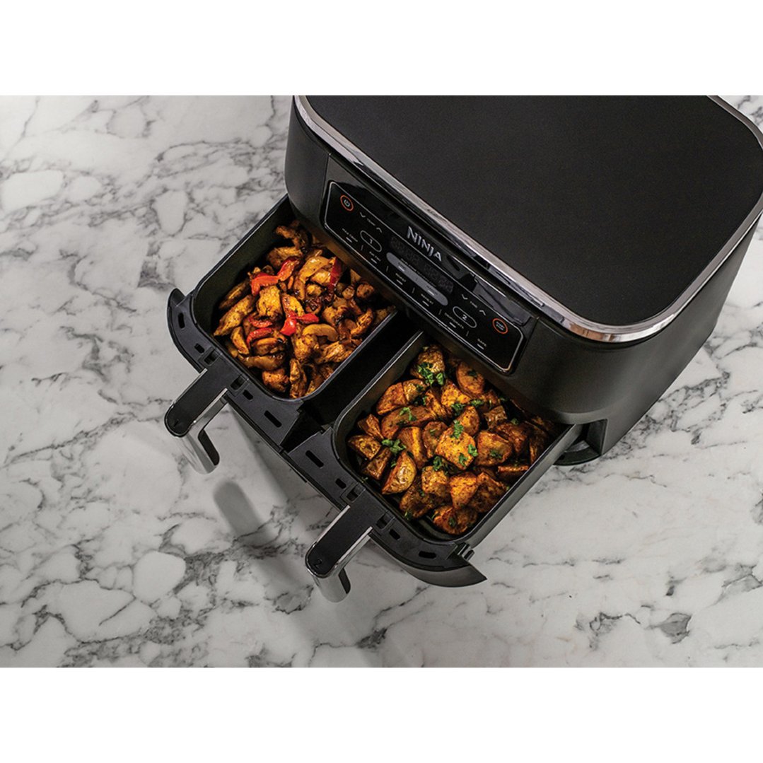 Ninja Foodi Dual Zone Air Fryer with two baskets of cooked food
