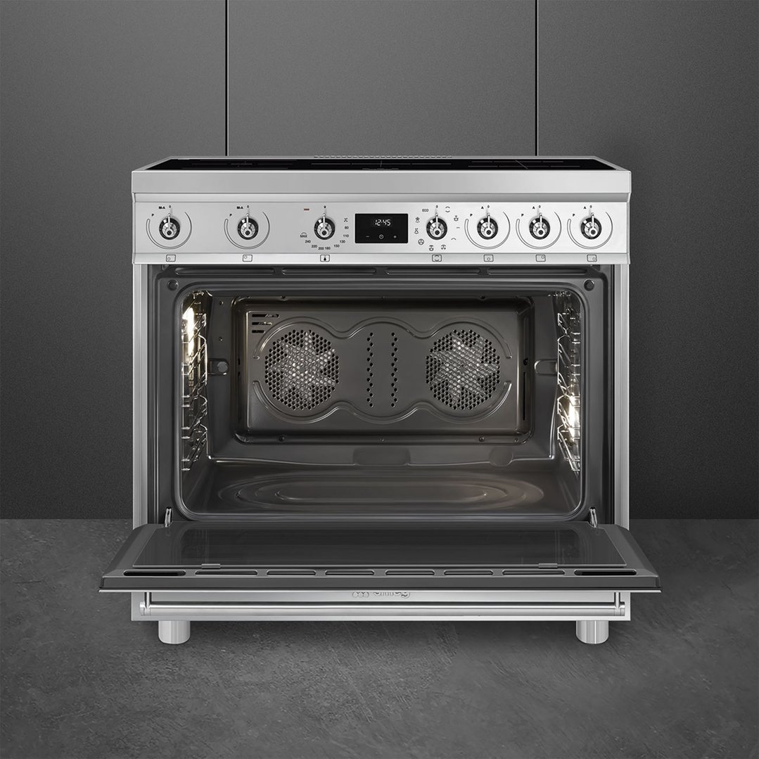 Stainless steel freestanding cooker with oven door open, showing interior and controls