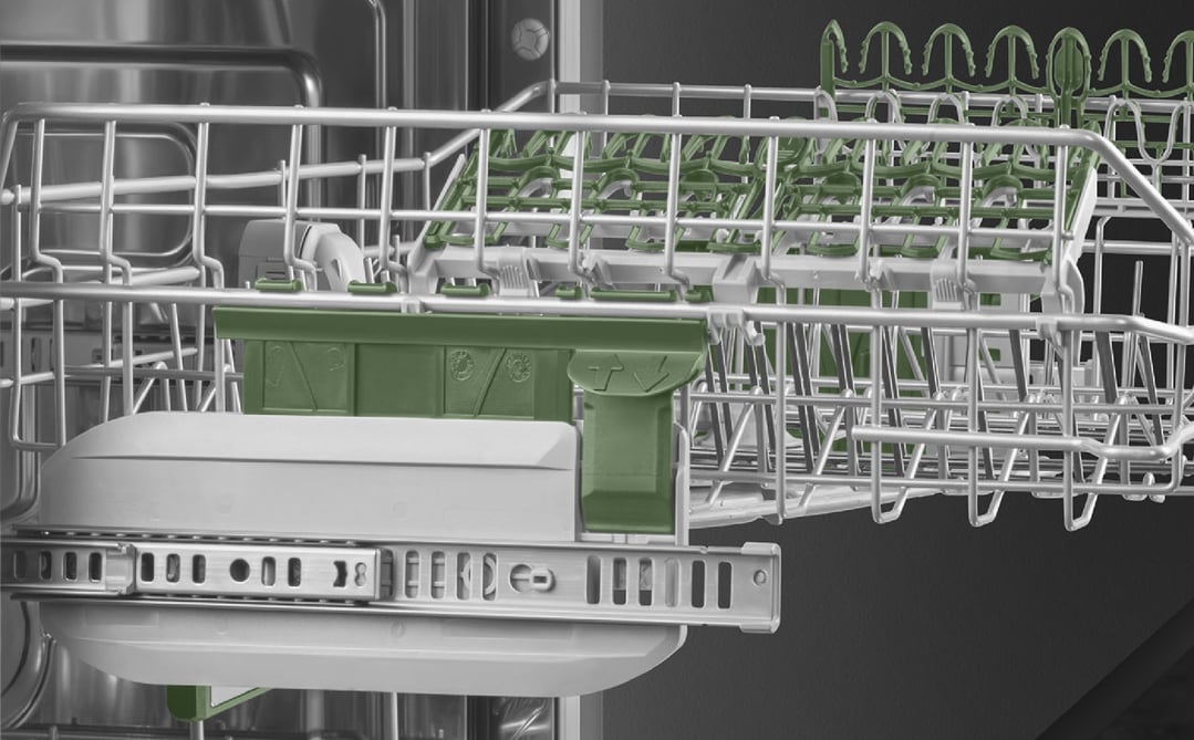 Close up of the top rack of a dishwasher with green accents