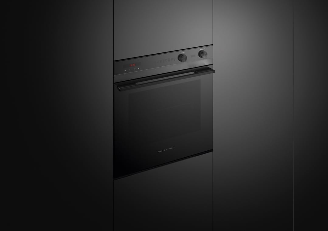 Built-in black oven with control panel and display in a dark kitchen setting