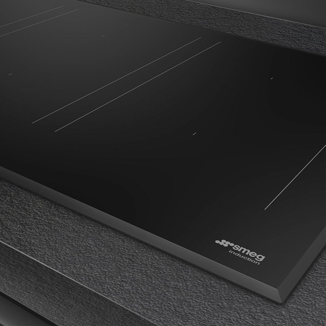 Black Smeg induction hob built into a dark textured countertop