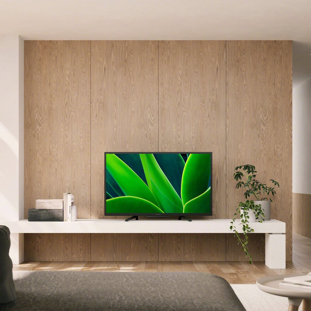 Sony TV on a white stand in a living room with wooden wall panels