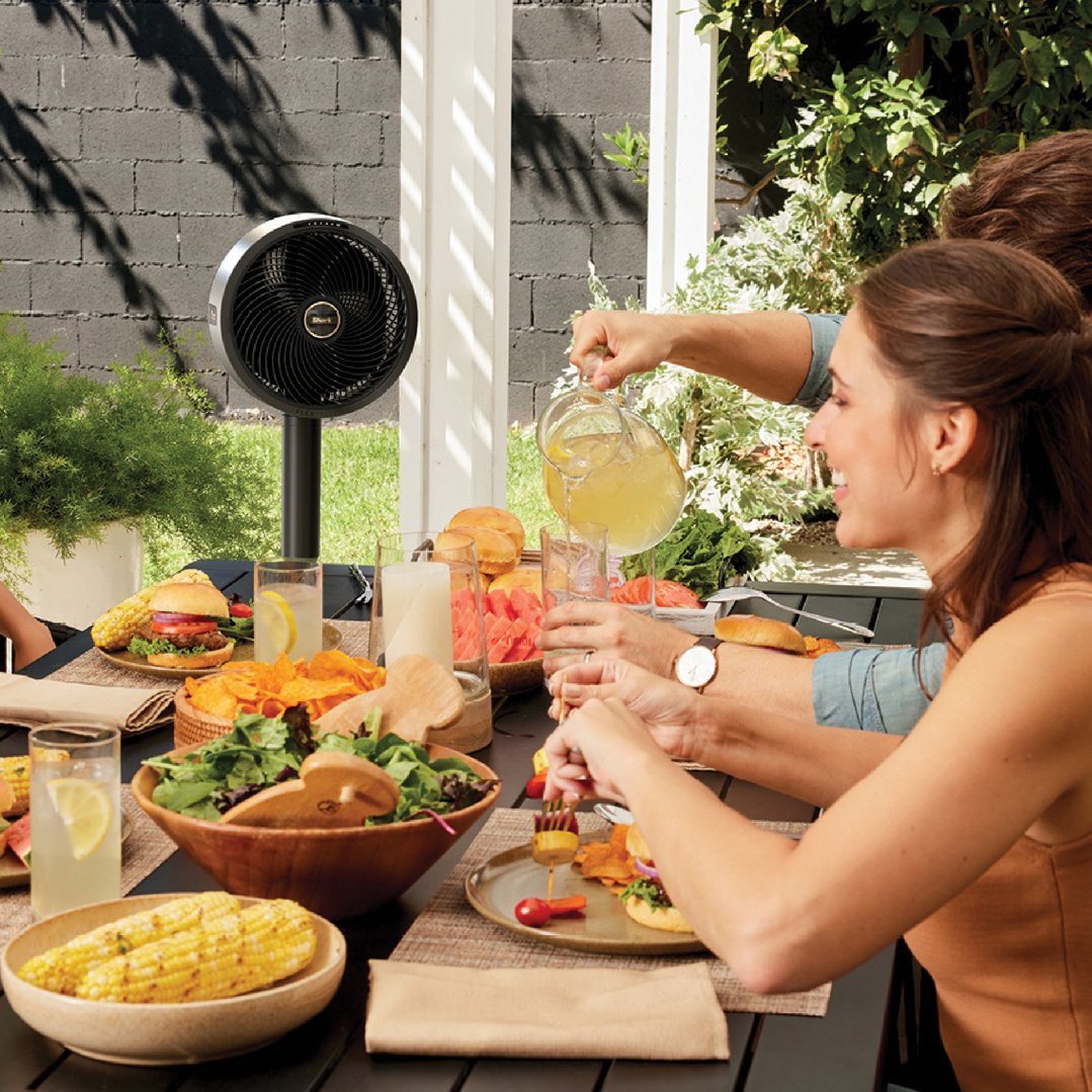 Shark FlexBreeze fan on a stand at an outdoor dining table with people