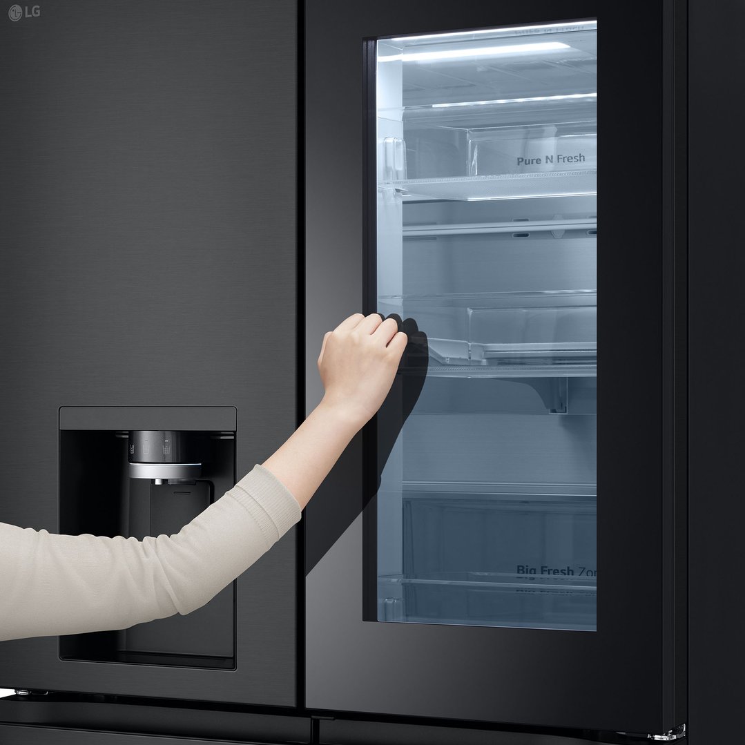 Hand opening the door of a black LG French Door fridge