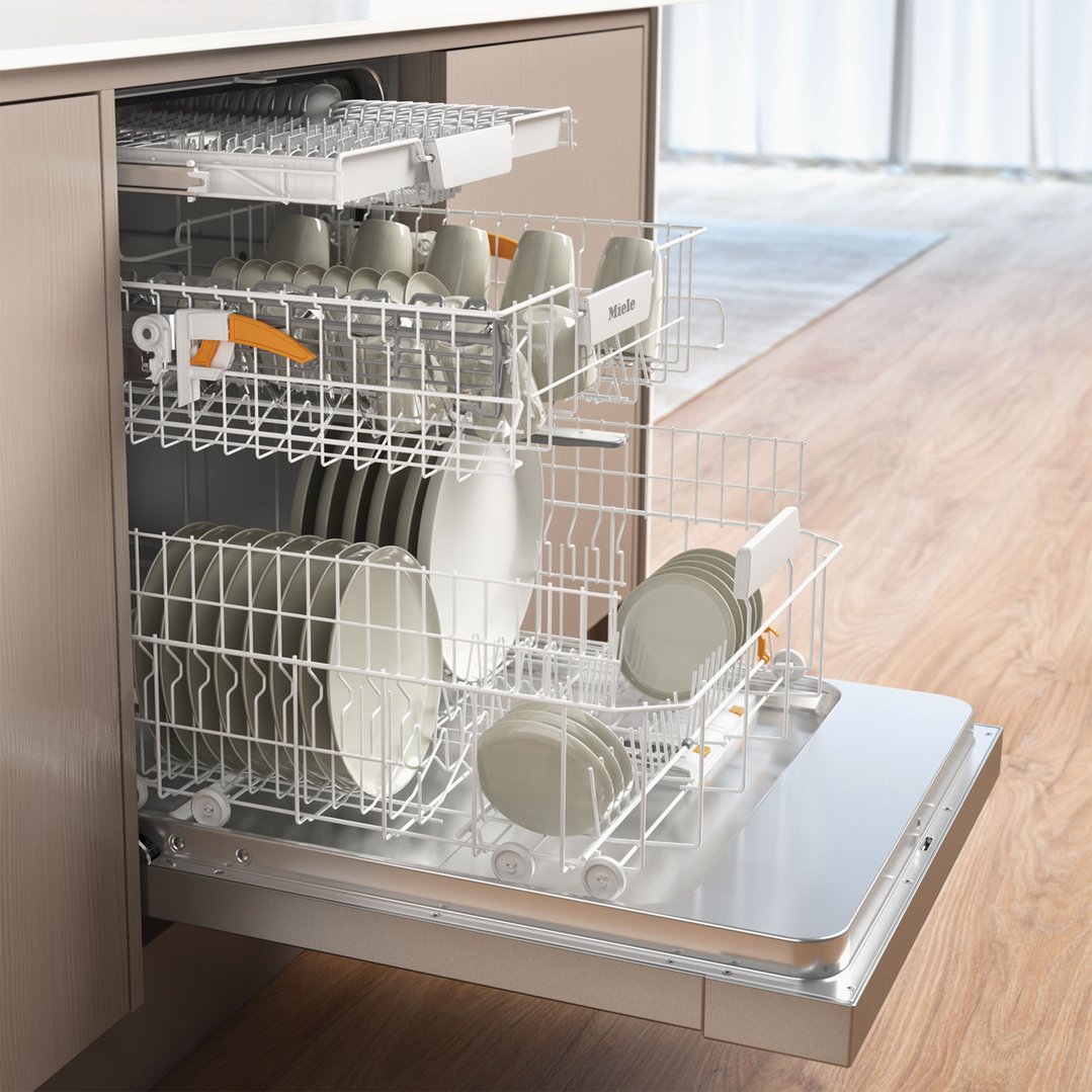 Open Miele dishwasher with dishes inside, in a kitchen setting
