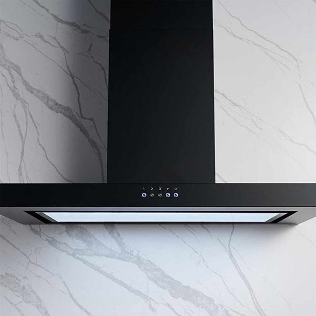 Black canopy rangehood mounted on a white marble-patterned wall