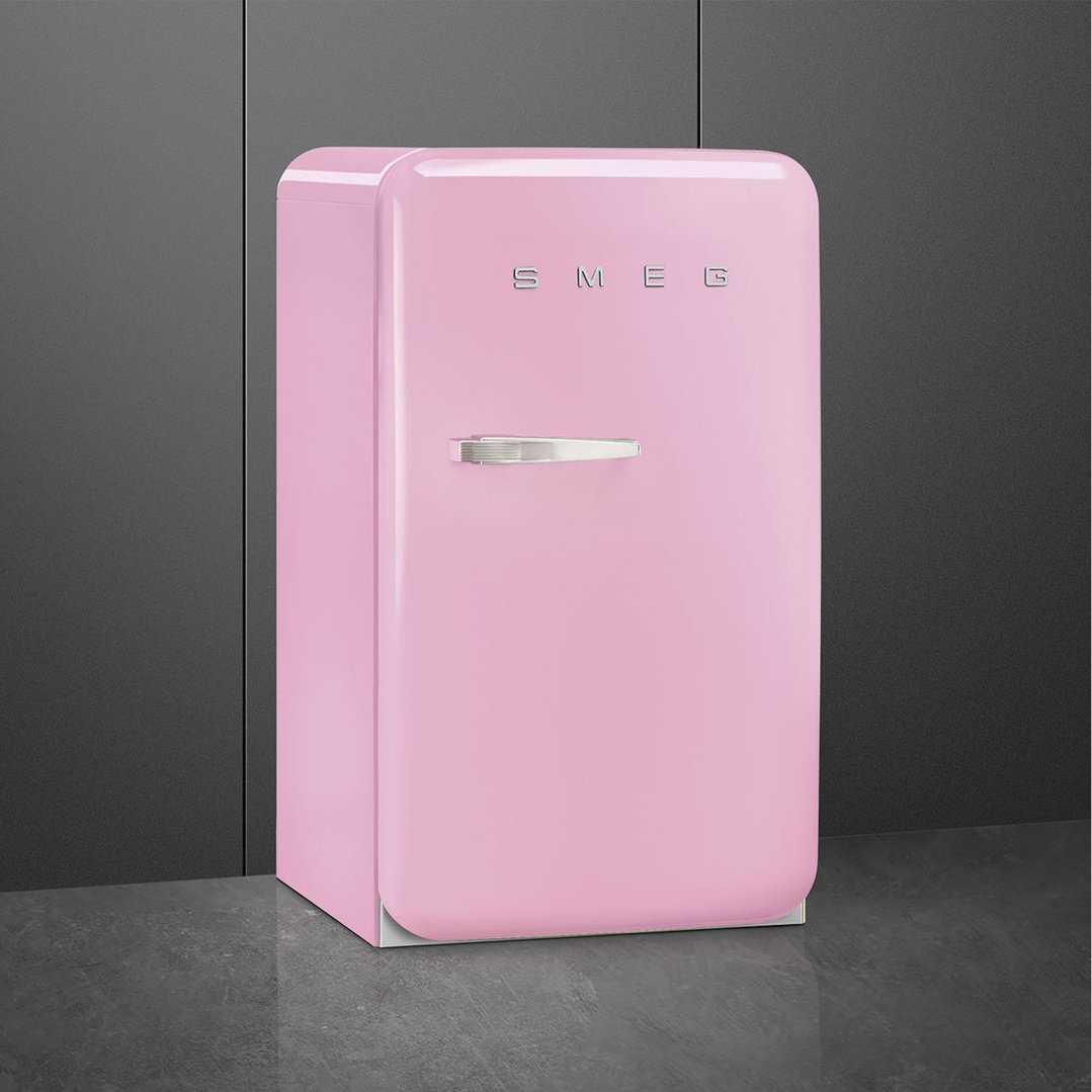 Pink SMEG refrigerator with right hand hinge on a dark grey floor