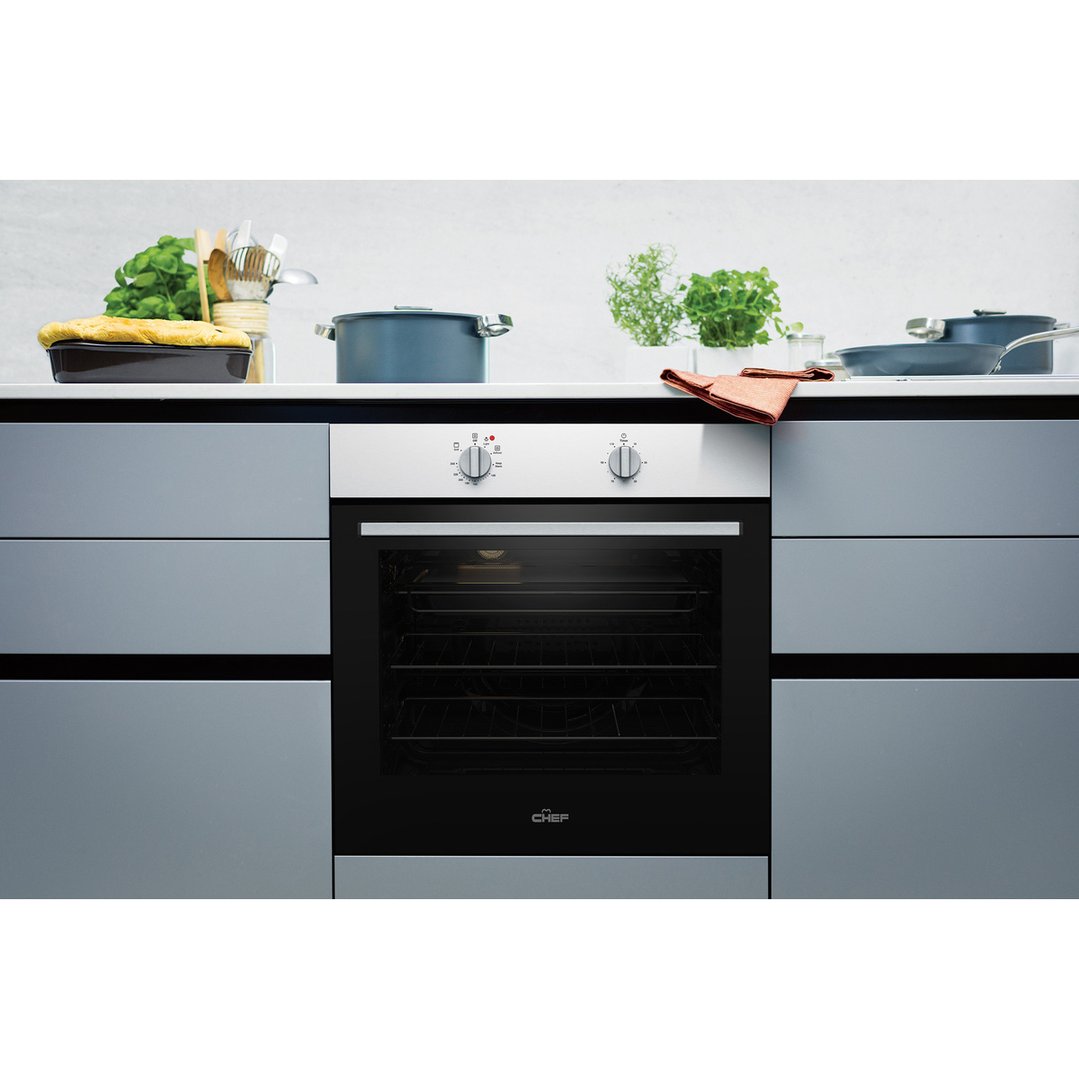 Built-in Chef oven in a modern kitchen with cooking pots and herbs on the counter