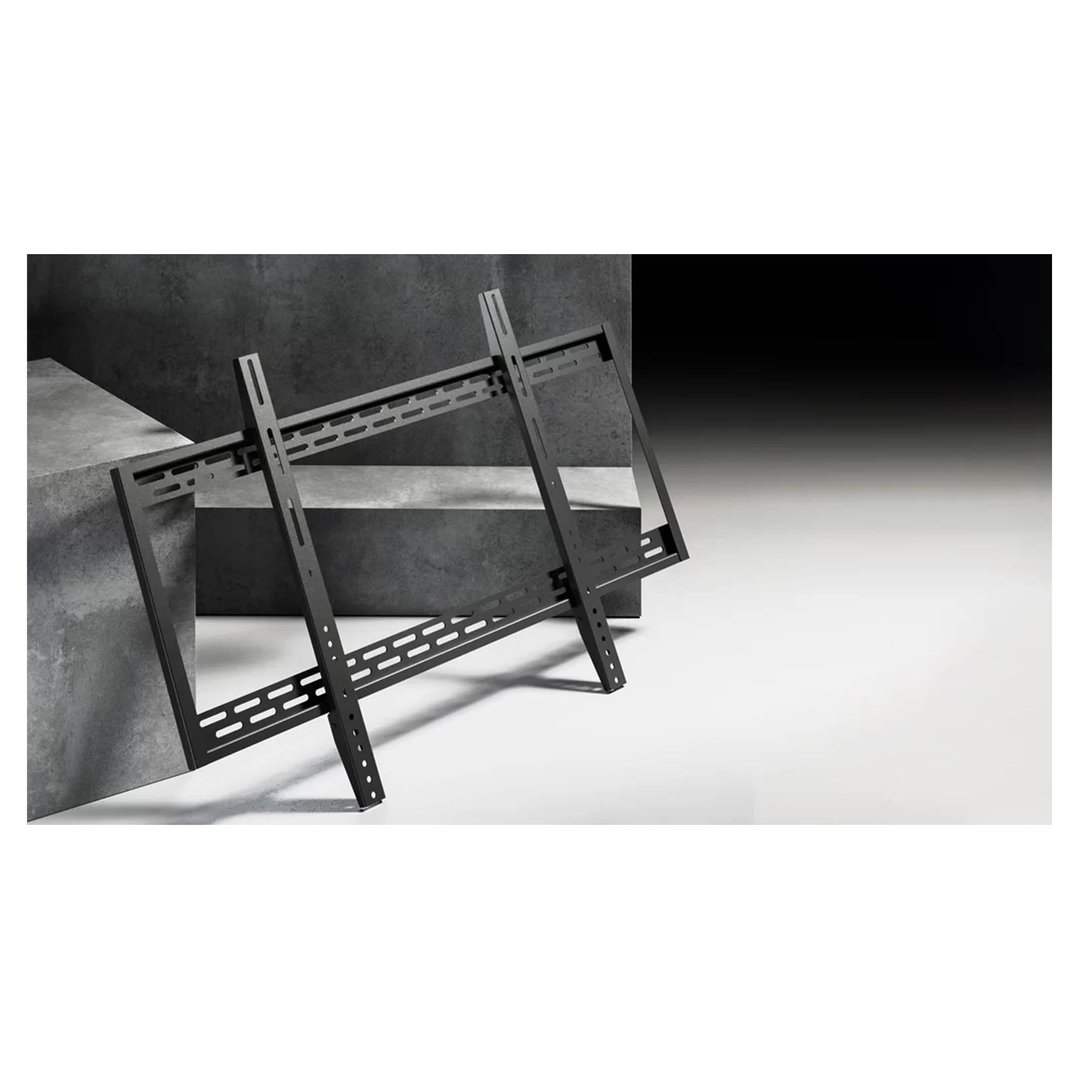 Black TV wall mount leaning against concrete blocks in a studio setting