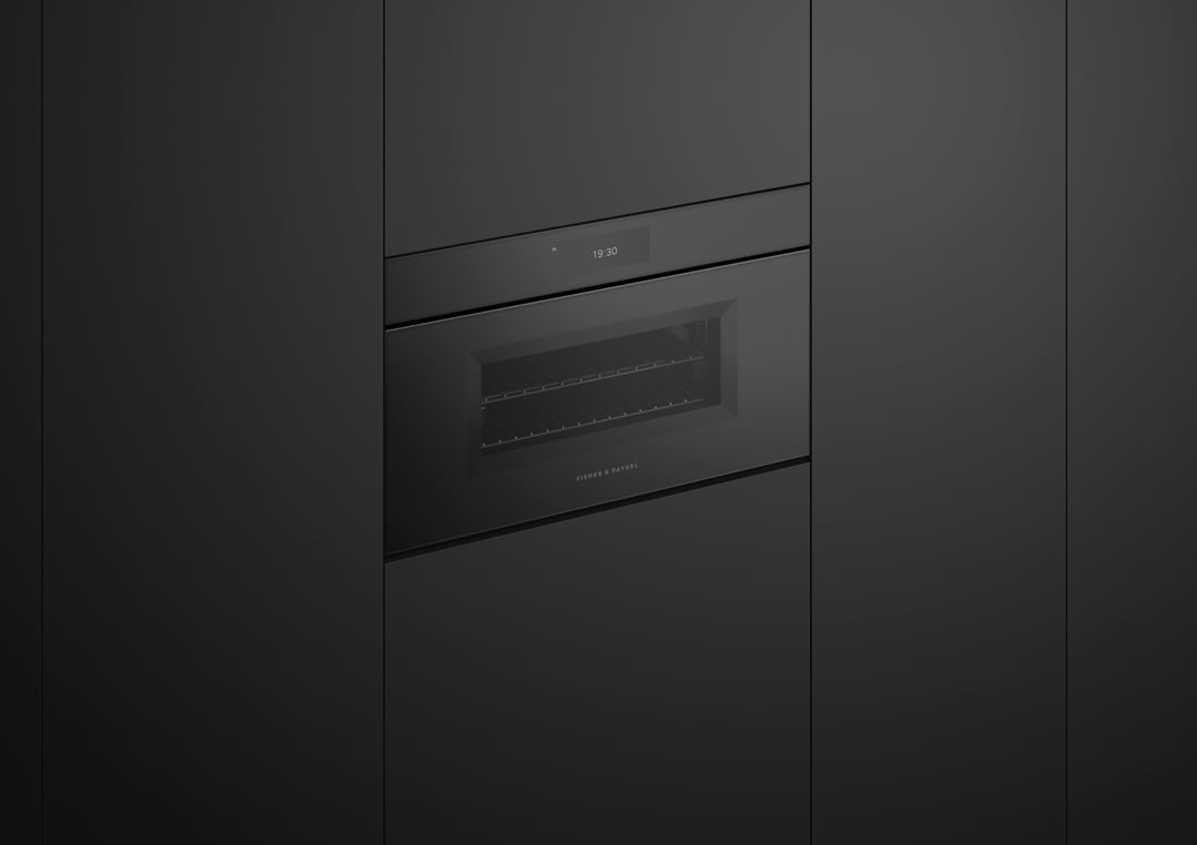 A black combi-steam oven built into dark cabinetry, displaying the time 19:30
