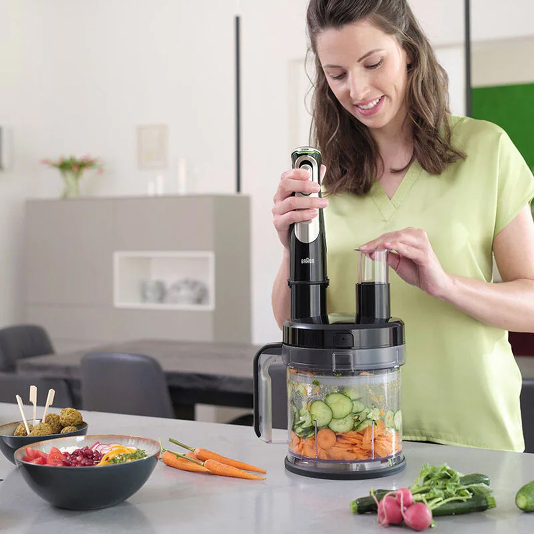 Woman using a Braun MultiQuick 9 Hand Blender to chop vegetables in a kitchen