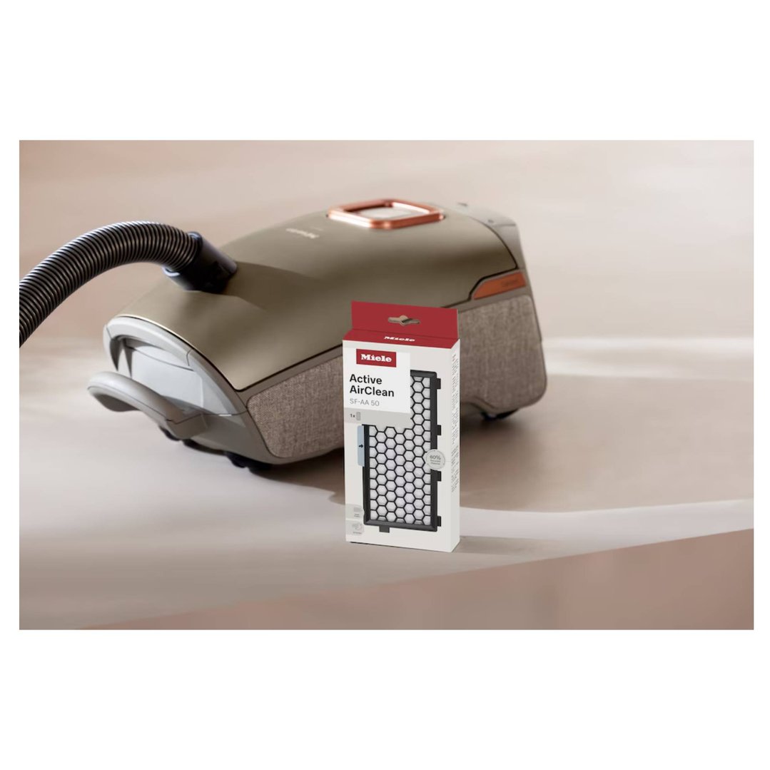 Miele Active AirClean filter box next to a vacuum cleaner on a light surface