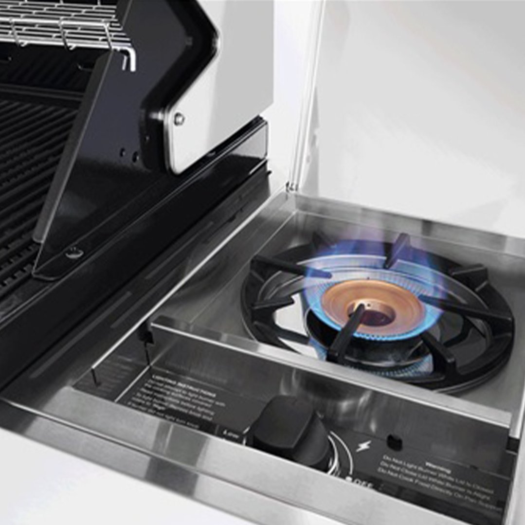 Close up of a side burner on a barbecue with blue flame