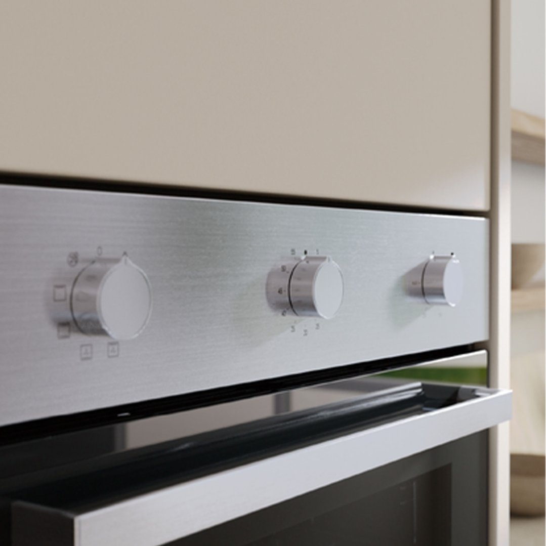 Close-up of a built-in oven's control panel and handle in a kitchen setting