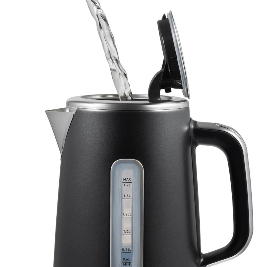 Water being poured into a black kettle with a visible water level indicator