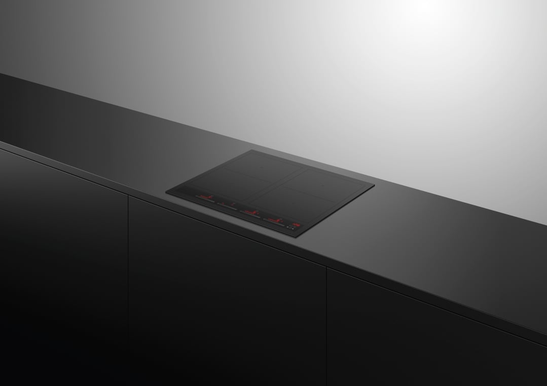 Black 4 zone induction cooktop built into a dark kitchen counter
