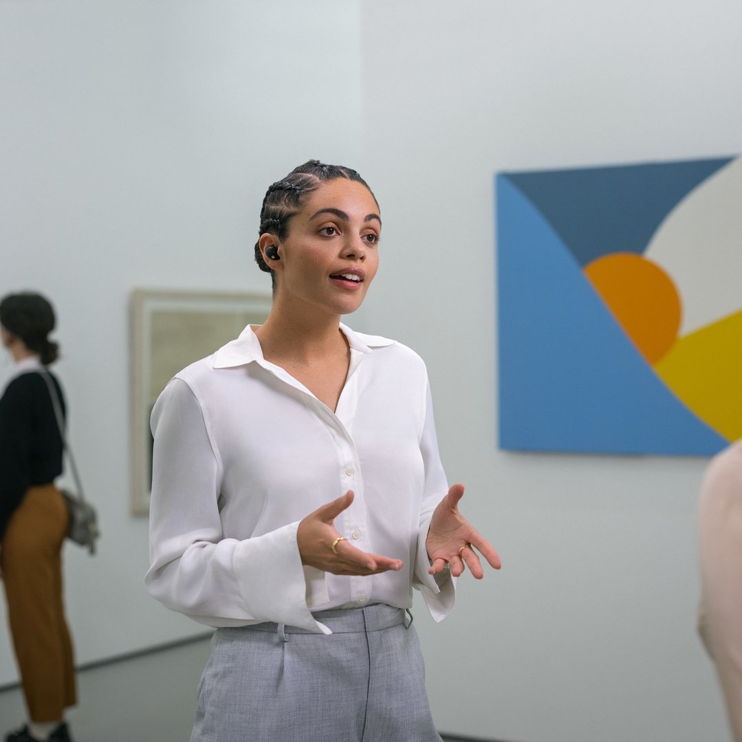 Woman wearing Sony Truly Wireless Earbuds talking in an art gallery
